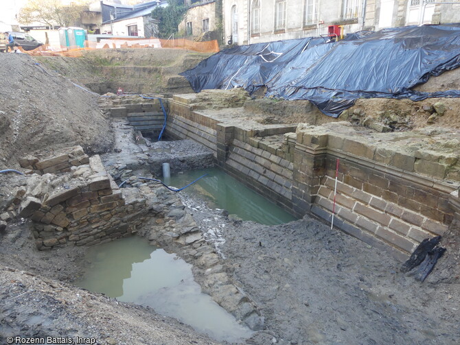 Vestiges du château de l'Hermine à Vannes (Morbihan) en cours de fouille. Cette façade qui forme l'escarpe de la douve, mise en eau grâce au canal, est aménagé en glacis (pente douce) avant de plonger à la verticale sur une hauteur totale de 4,50 mètres jusqu'au fond de la douve.