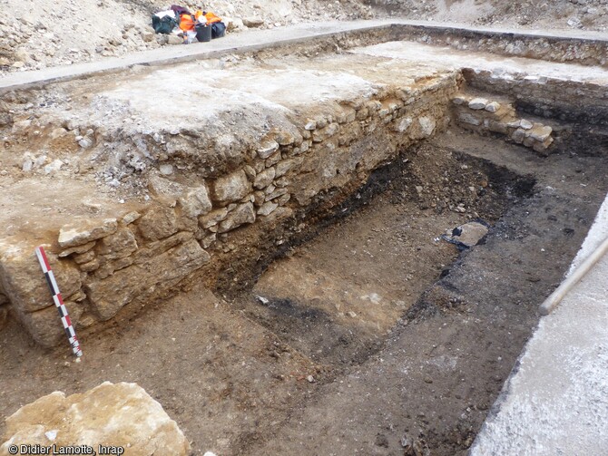 Cave de la fin de la période médiévale installée contre la paroi nord du castrum (en arrière-plan) de l'Antiquité tardive, place du Maréchal Leclerc à Auxerre (Yonne).