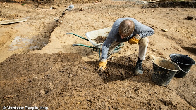 Décapage manuel afin d' atteindre le niveau des canalisations  du chantier de fouille de Mâcon (Saône-et-Loire) en 2024.  Un quartier résidentiel antique y a été découvert.