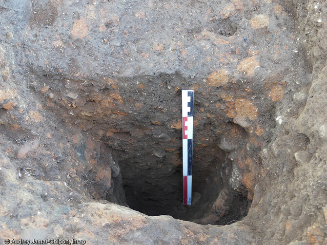 Vue en coupe d'un trou de poteau et du fantôme de poteau conservé à Ghisonaccia (Haute-Corse). Une vingtaine de ces trous de poteaux, dont certains ont conservés leurs fantômes, ont été appréhendés en périphérie de l'habitat de l'établissement étrusque du VIe-IVe siècle avant notre ère. 