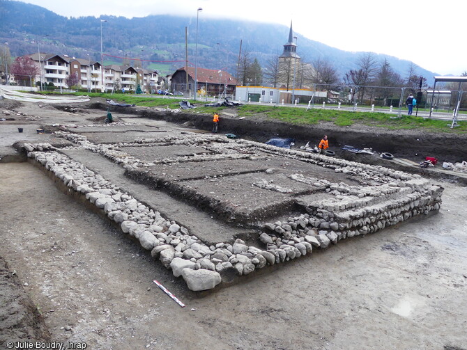 Vue des deux bâtiments successifs construit sur la terrasse basse à Thyez (Haute-Savoie). Au cours du Ier siècle, la terrasse basse a été remblayée pour en faire un terrain constructible. Ce terrain a accueilli un bâtiment rectangulaire de 7,5 m de largeur sur 25 m de longueur. Il a été détruit au cours du IIe s et a été partiellement reconstruit. 