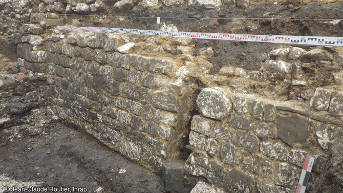 Paroi de protection de la fosse de travail de l'atelier de potier à Montreuil-sur-Mer (Pas-de-Calais). Cette fosse excavée et profonde de 2 m est protégée côté nord par une paroi de moellons calcaires inclinée (long 8 m, haut 1,50 m) dotée d'un renfort saillant en grès dont seule subsiste une pierre en place. 