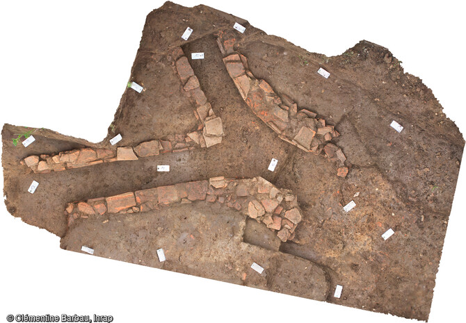 Orthophotographie du conduit de chauffage gallo-romain découvert sur le site de Brumath.Le décapage de la partie nord-est du site a permis de mettre au jour ce conduit linéaire composé de deux murets construits avec des fragments de tegulae, de briques et de tubuli en remploi liés à la terre et se prolongeant dans la berme.