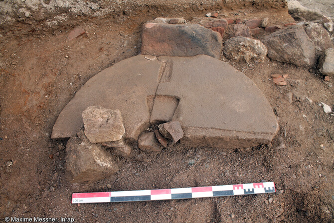 Vue d'une meule utilis&eacute;e en remploi dans la ma&ccedil;onnerie du bassin associ&eacute; au b&acirc;timent meunier fin XVIIe - d&eacute;but XVIIIe si&egrave;cle.