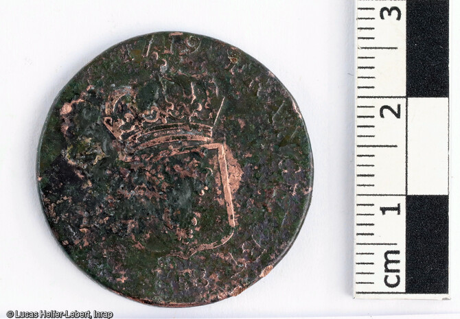 D&eacute;tail d'une pi&egrave;ce provenant d'un petit corpus de quatre monnaies d&eacute;couvert sur le site de Ch&acirc;tenois (Bas-Rhin).C'est un demi-sol au buste enfantin de Louis XV.&Eacute;cu de France couronn&eacute;.Cuivre, diam : 28 mm, poids : 10,83 gAnn&eacute;e : 1719. Atelier : Strasbourg.