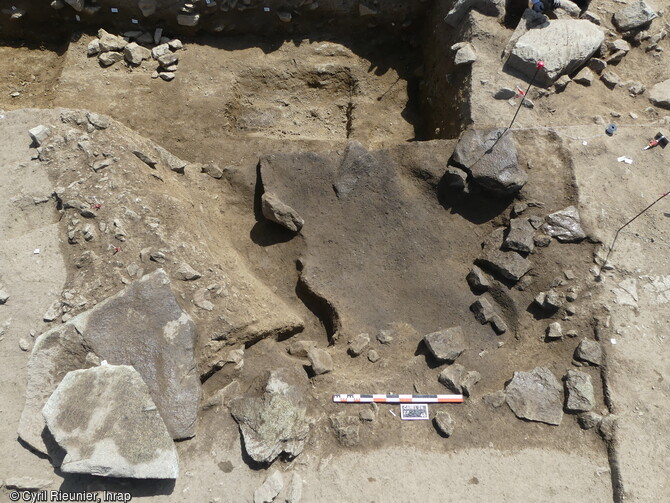 Fouille d'un b&acirc;timent du N&eacute;olithique sur le site de la Carella &agrave; Font-Romeu-Odeillo-Via (Pyr&eacute;n&eacute;es Orientales). Vue du d&eacute;tail du mur en terre et pierre, de l'enduit de terre sur le bord d'une fosse et du niveau charbonneux dans la fosse. 