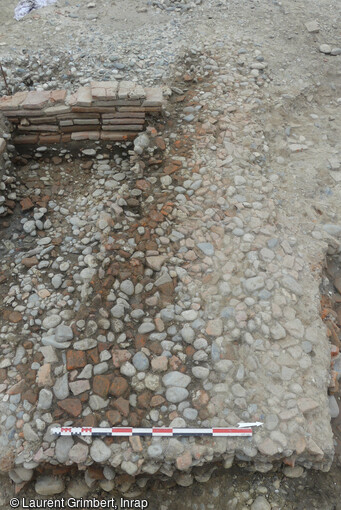 Vue générale d'un niveau de rue, attribuable à l'Antiquité tardive découvert lors de la fouille de la future station de métro François Verdier à Toulouse (Haute-Garonne). Plusieurs niveaux de rues ont été mis au jour, ils sont constitués de galets mêlés de fragments de terre cuite et compactés par un usage intensif. 