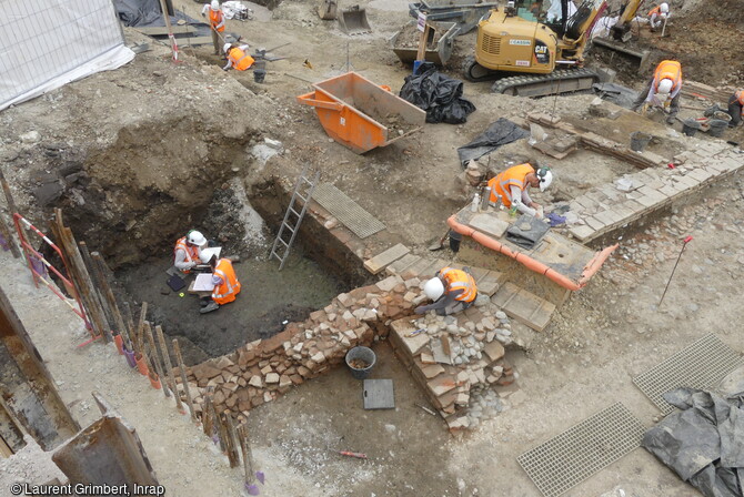 Vue du secteur nord du chantier de fouille de la future station de métro François Verdier à Toulouse (Haute-Garonne). Les niveaux de rues sont visibles sur la droite, sur la gauche deux archéologues entament la fouille d'une cave médiévale. 