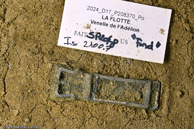 Boucle ceinture en alliage cuivreux, à décor d'entrelacs découverte dans une inhumation à La Flotte sur l'île de Ré (Charente-Maritime). Ce décor d'entrelacs évoque le monde anglo-Saxon. L'observation du mobilier retrouvé au cours de la fouille tend à rapprocher celui-ci de la culture matérielle des sociétés de la mer du Nord et n'a pas d'équivalent en France ce qui rend les comparaisons difficiles. Les analyses de ces matériaux permettront de connaître leur origine.