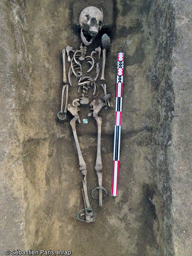 Inhumation probable d'une femme immature (7-12 ans) mise au jour dans l'enclos en forme de fer à cheval à Plancy-l'Abbaye (Aube). Le corps s'est décomposé dans un espace vide (contenant rigide avec couvercle). elle est accompagnée d'un dépôt de bracelets, anneaux de cheville et fibules attribués au Hallstatt D3-La Tène A1 (-500-430 avant notre ère. 