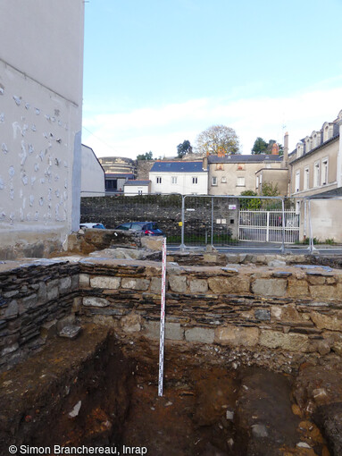 Vue d'un mur des écuries de l'Académie royale d'équitation(XVIIe-XVIIIe siècles) surmontant les strates de l'occupation médiévale du site, à Angers (Maine-et-Loire).