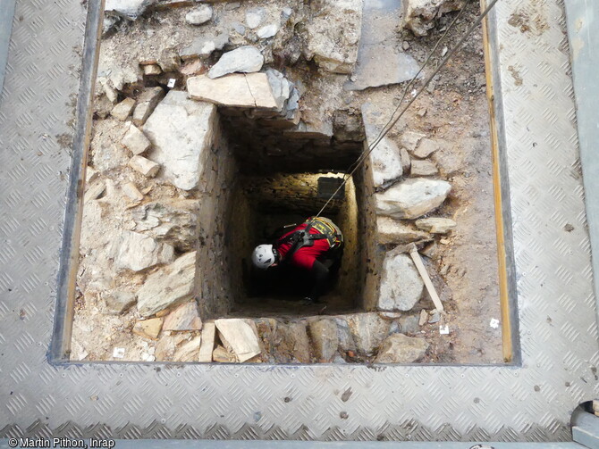 Fouille en cours de la fosse de latrine maçonnée (XIVe-XVe siècle) par un archéologue de la CISAP à Angers (Maine-et-Loire).