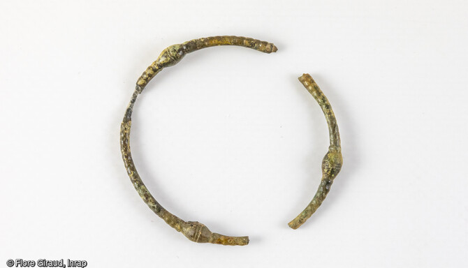 Bracelet en alliage cuivreux présentant trois bourrelets équidistants bien marqués et surlignés d’un double trait incisé.