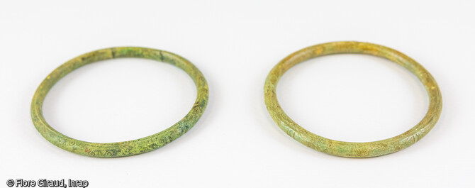 Paire de bracelets en alliage cuivreux ornés de décors incisés. 