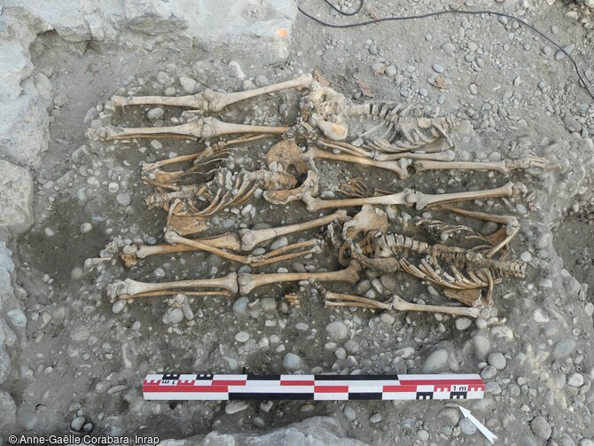 Dépôts simultanés de trois individus.  Deux structures funéraires se démarquent nettement puisqu’elles associent des dépôts simultanés d’un nombre d’individus plus important. La structure plurielle, découverte au centre du bâtiment, associe à la fois des dépôts primaires en connexion, retrouvés sur plusieurs niveaux superposés et des restes osseux déconnectés retrouvés pêle-mêle, le tout dans un grand désordre. 