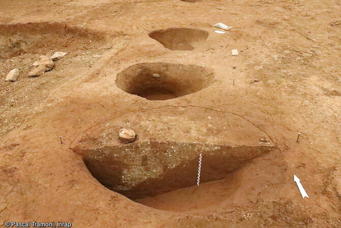 Vue du comblement d'un trou de poteau latéral sur le site du Domaine de la Vallée Verte à Marseille (Bouches-du-Rhône). Ce comblement est composé d'argile blanc crème à carbonate, utilisé comme calage, et d'un bouchage  réutilisant les marnes rouges provenant du creusement. Ce comblement est similaire pour les poteaux faîtiers et les poteaux absidiaux. 