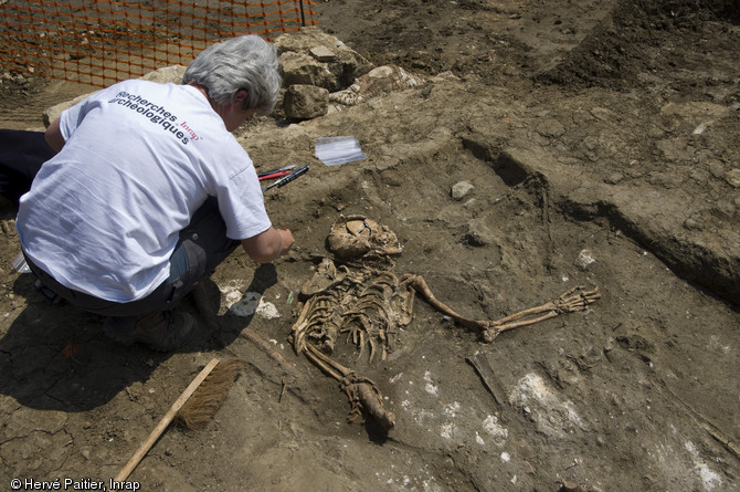 Démontage de la partie supérieure d'un squelette d'adulte dans une des fosses contenant des victimes de la bataille du Mans (12 et 13 décembre 1793), Le Mans (Sarthe), 2010.  Hormis quelques adolescents, tous les sujets dégagés par la fouille sont des adultes, tant hommes que femmes. 