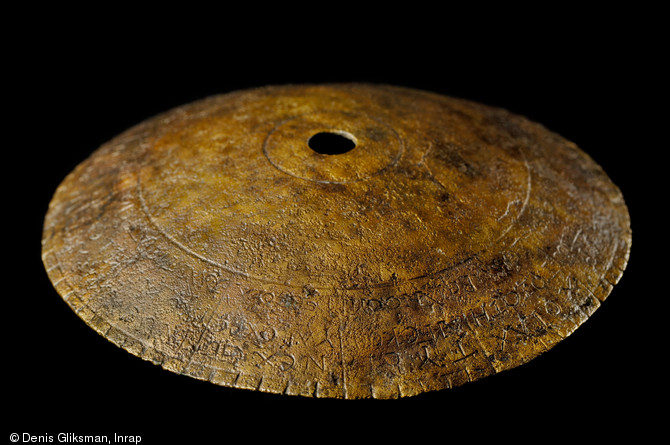 Disque astrologique en tôle de bronze daté de la fin du IIIe s. de notre ère, découvert dans l'agglomération gallo-romaine de Chevroches (Nièvre), 2001.  Des fautes de gravure ont été constatées, laissant penser que l'artisan maîtrisait mal le grec. Les lettres communes aux alphabets grec et latin ne lui ont en revanche pas posé problème. 