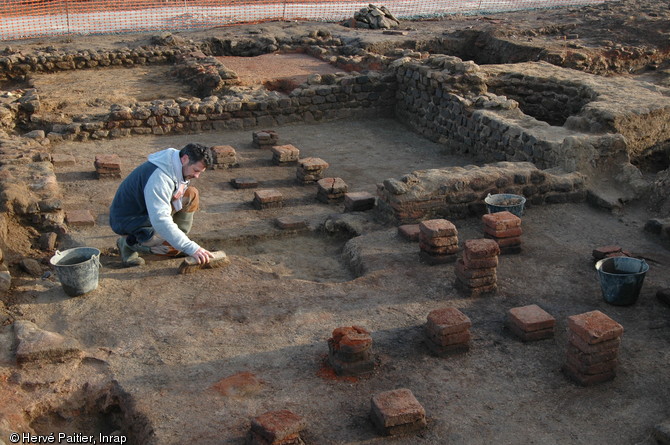 Fouille d'un hypocauste (système de chauffage par le sol) sur le chantier de la villa gallo-romaine des Alleux (Côtes-d'Armor), 2005-2006.  Ce système marque la richesse des propriétaires : il est destiné à chauffer les thermes privés de la villa qui s'étendent sur près de 200 m2. 