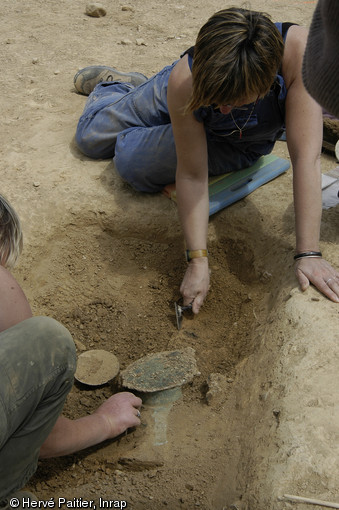 D&eacute;gagement d'une casserole en bronze dans une des tombes de la n&eacute;cropole de Saint-Marcel (Morbihan), Ve s. de notre &egrave;re, 2006. 