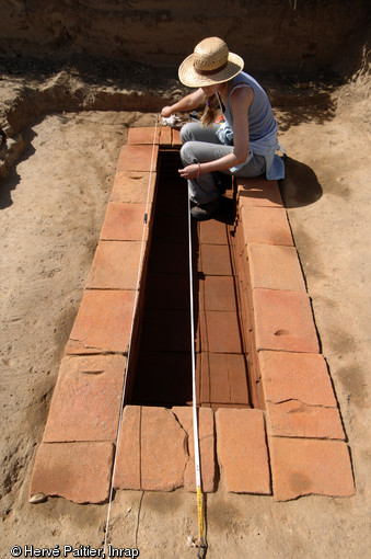 Sépulture à inhumation d’un enfant (8 - 9 ans) dans un caveau en briques, IIe-IIIe s. de notre ère, Neuville-sur-Sarthe (Sarthe), 2010 (dimensions : longueur 2,40 m, largeur 1 m).  La mise au jour d’une telle tombe dans l’enceinte sacrée d’un temple gallo-romain pose la question de leur éventuelle contemporanéité, en effet il est de règle à l’époque gallo-romaine de séparer ce qui est « pur » (les temples) de ce qui est « impur » (les inhumations par exemple). 