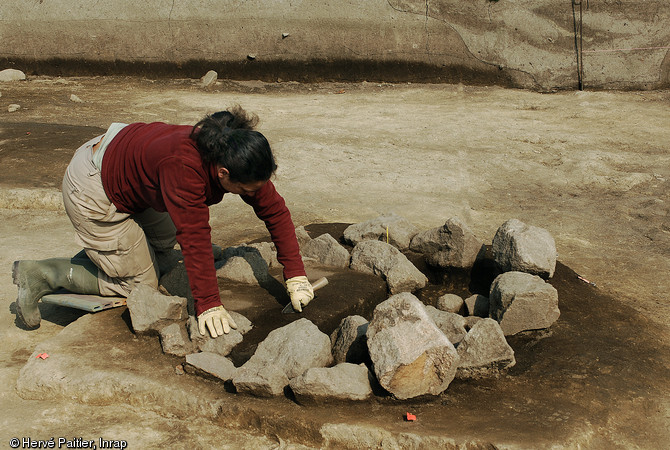 Fouille d'une structure&nbsp;de combustion &agrave; Carnac sur le site N&eacute;olithique moyen (4500 avant notre &egrave;re) de Montauban (Ille-et-Vilaine), 2009.  En batterie ou isol&eacute;es, ces structures se caract&eacute;risent par des dimensions relativement standardis&eacute;es (environ 1m de diam&egrave;tre) et par un comblement de pierres jointives ayant subi l'action du feu. 