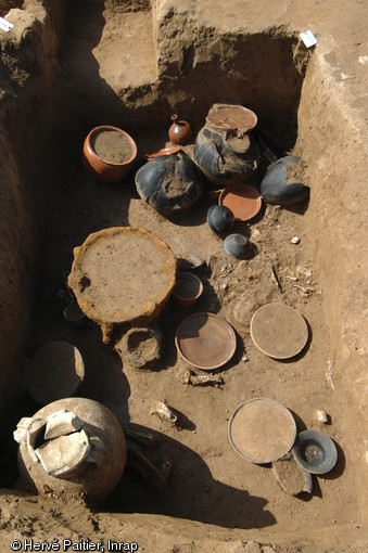 Fosse sépulcrale abritant la sépulture à incinération d'un auxiliaire gaulois de l'armée romaine, dernier quart du Ier s. avant notre ère, Oisy-le-Verger (Pas-de-Calais), 2010.  Ce sont le contexte de la découverte et le mobilier, associant notamment une amphore espagnole à garum (en bas à gauche du cliché) et de la vaisselle fine italique, qui ont permis de qualifier le défunt. 