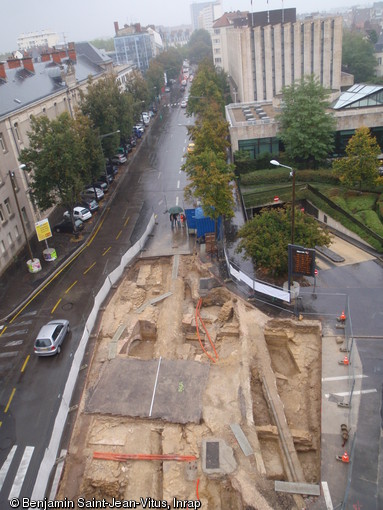 Vue générale de la fouille boulevard de la Trémouille à Dijon, 2010.  On y voit la muraille médiévale encadrant la tour rectangulaire du XIVe siècle avec ses arches laissant passer le Suzon et les deux quais encadrant le lit médiéval du Suzon. Tout ce dispositif est daté globalement du XIVe siècle. 