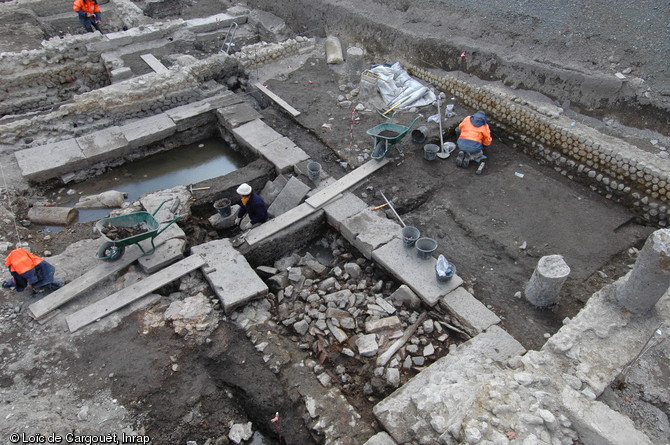 Bassin en  L  appartenant à un édifice à portique interprété comme des thermes publics gallo-romains mis au jour lors de la fouille du  Carré Jaude 2  à Clermont-Ferrand (Puy-de-Dôme), 2010.  Une colonnade bordant se bassin est visible dans la partie droite de la photographie.   