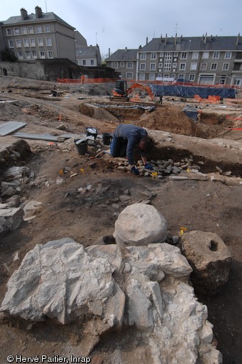 Fouille entre le vestibule et la cella du mithraeum d'Angers (Maine-et-Loire), 2010.  Le mithraeum apparaît comme un bâtiment rectangulaire excavé : du vestibule on accède à la cella où se déroulent les différents rites du culte (initiations, repas rituels...).  