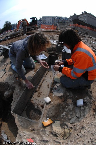 Fouille d'une tombe en coffre de schiste, VIe-VIIe s. de notre ère, Angers (Maine-et-Loire), 2010.  Il s'agit d'une des sépultures médiévales mises au jour sur le site, attestant de la permanence de l'occupation de ce quartier d'Angers. 