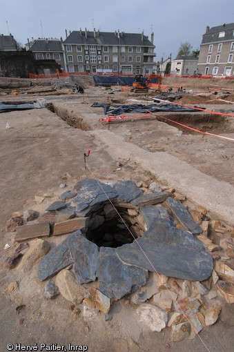 Vue des vestiges d’un sanctuaire voué au culte de Mithra, dieu d’origine indo-iranienne, en cours de fouille à Angers (Maine-et-Loire), 2010.  Le mithraïsme est probablement introduit dans l’Empire  par les militaires romains et les marchands orientaux et se  répand à la fin du Ier siècle. Ce culte à mystères, réservé aux hommes, séduit d’abord les élites, puis se diffuse dans toutes les couches de la société. Concurrent du christianisme, il est fortement combattu et finalement interdit par l’empereur Théodose en 392.