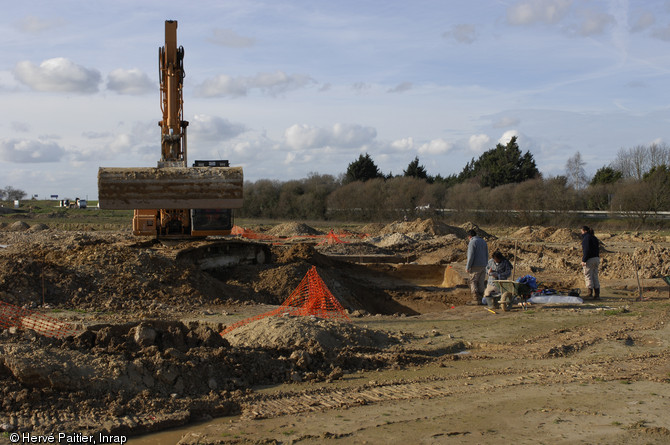 Sondage à la pelle mécanique sur le fossé de l'établissement du Bronze final de Lamballe (Côtes-d'Armor), 2006-2007.  A la fin de l'opération, lorsque les vestiges ont été étudiés, des sondages mécaniques systématiques peuvent être mis en place pour prélever le mobilier archéologique resté dans les fossés. 