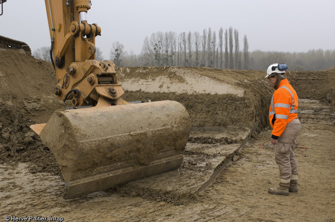 Décapage en cours sur le site d'Alizay (Eure), 2011.  Situé à la confluence de la Seine et de l'Eure, le site présente un niveau de conservation remarquable, fossilisant les témoins de la présence humaine sous d'épaisses couches de terre.  