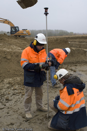 Relevé topographique en cours sur le site d'Alizay (Eure), 2011.  L'étude topographique est une étape essentielle de la reconstitution de la géométrie des sols, un des objectifs de l'opération d'Alizay. Elle est également indispensable à la réalisation des différents plans du site. 