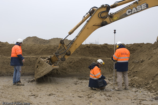 Décapage et relevé topographique sur le site d'Alizay (Eure), 2011.  Ces deux opérations permettent de faire apparaître les structures archéologiques ainsi que de dresser un premier plan du site, deux étapes indispensables avant de débuter la fouille. 