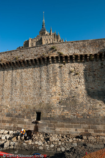 Portion du mur de fortification du Mont-Saint-Michel (Manche) à l'emplacement de l'ancienne Tour Denis, 2011.  Les vestiges de cette dernière sont visibles au bas de la photo. Au dessus, les assises de pierre de taille mises en place à partir de 1732 qui ont entraîné la destruction de la tour. 