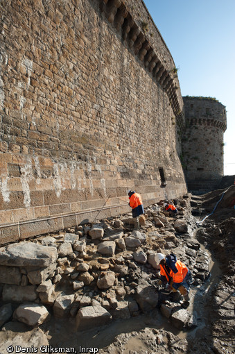 Vestiges de la Tour Denis en cours de fouille, Mont-Saint-Michel (Manche), 2011.  Les fortifications du Mont-Saint-Michel situées sur grève ont été remaniées à partir de 1732 : leur consolidation a notamment portée sur la mise en œuvre d'assises en pierres de taille, reposant ici sur l'arase de la Tour Denis. 