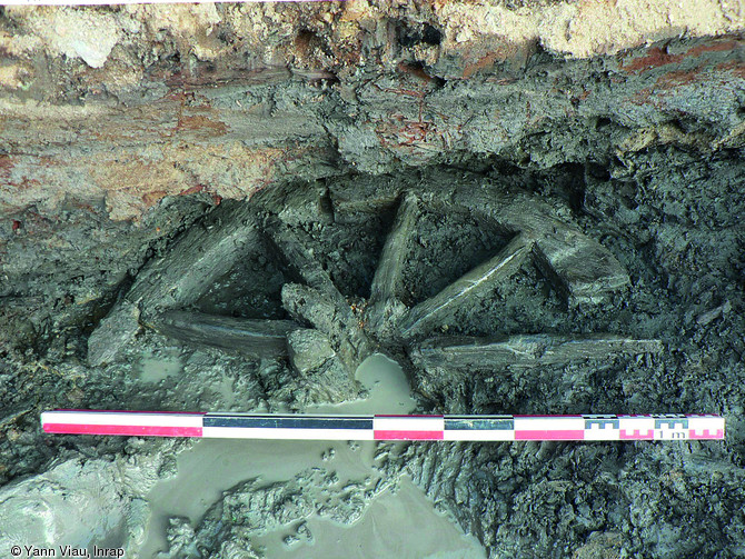 Demi-roue compl&egrave;te (jante, rayons, moyeu) provenant d'un moulin &agrave; eau dat&eacute; entre le VIIIes. et le Xes. &agrave; Notre-Dame-du-Marillais (Maine-et-Loire), 2008.  A la fin du Xe s. ou au d&eacute;but du XIe s., le site est abandonn&eacute; avant qu'un comblement naturel ne vienne le sceller, maintenant un taux d'humidit&eacute; suffisant &agrave; la conservation des vestiges organiques.  Photo publi&eacute;e dans le num&eacute;ro 23 de la revue de l'Inrap <a class= rte-link-ext  href= http://www.inrap.fr/archeologie-preventive/La-Recherche/Archeopages/La-revue/p-9131-A-propos.htm  targ