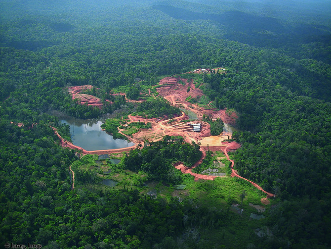 Vue a&eacute;rienne du site de Yaou (Guyane), 2006.  Au premier plan apparaissent les d&eacute;gradations anciennes de l'orpaillage traditionnel, qui ont modifi&eacute; le trac&eacute; initial du cours d'eau. Au deuxi&egrave;me plan, l'exploitation actuelle du gisement aurif&egrave;re qui s'attaque au relief. Au troisi&egrave;me plan, la base arch&eacute;ologique implant&eacute;e sur le massif tabulaire de Yaou. A l'horizon, la zone de prospection, recouverte par la for&ecirc;t tropicale.   Photo publi&eacute;e dans le num&eacute;ro 23 de la revue de l'Inrap <a class= rte-link-ext  href= http://www.inrap.fr/archeologie-preventive/Recherche-scientifique/Archeopage