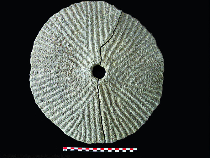 Meta (meule dormante) provenant du site du 25 rue Saint-Fiacre &agrave; Meaux (Seine-et-Marne), d&eacute;couverte en remploi dans une structure&nbsp; dont le comblement est dat&eacute; du IIIe s. de notre &egrave;re. Fouille men&eacute;e en 2006.  Elle pr&eacute;sente un habillage de la surface active par rayonnage.  Photo publi&eacute;e dans le num&eacute;ro 28 de la revue de l'Inrap <a class= rte-link-ext  href= http://www.inrap.fr/archeologie-preventive/Recherche-scientifique/Archeopages/Les-numeros/28-29-30-HS02-2010/Numero-28/Pratiques/p-11763-Les-meules-du-Neolithique-au-Moyen-Age.