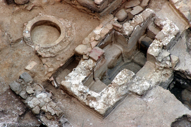 Aménagements successifs du baptistère paléochrétien et médiéval d'Ajaccio (Corse-du-Sud), 2005.Au centre le système initial, grande cuve en forme de croix (dimensions intérieures : 2,68 x 1,39m, profondeur 1,24m) aménagée dans le courant du VIe s. et permettant le baptême par immersion. A gauche le bassin cylindrique (80cm de diamètre, profondeur 28cm) qui le remplace au cours du haut Moyen Âge.     