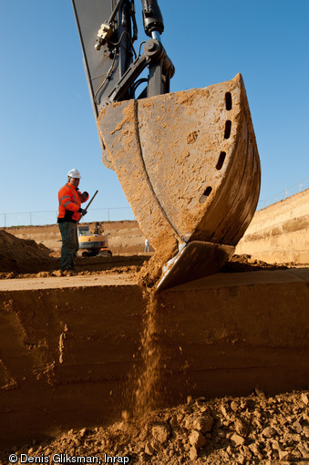 Décapage à la pelle mécanique, réalisé sur le site paléolithique d'Havrincourt (Pas-de-Calais), 2011.  Exceptionnel sur de si grandes surfaces (6000 m2) et à de telles profondeurs (jusqu'à 6 m), le décapage a permis d’identifier deux niveaux d’occupation datant approximativement de 50 000 ans pour le plus ancien, et d’environ 30 000 ans pour le plus récent. 