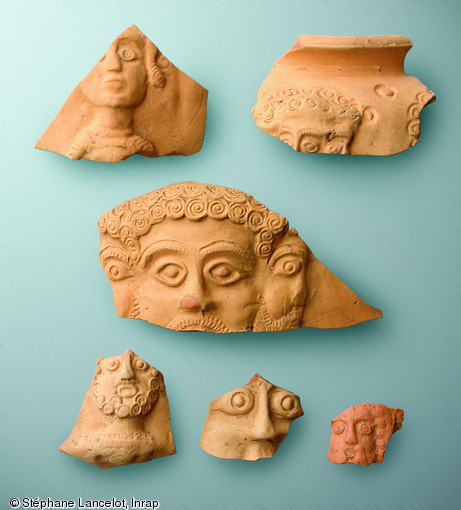 Fragments de vases &agrave; bustes montrant des divinit&eacute;s, IIIe s. de notre &egrave;re, Famars (Nord), 2008.  Au centre Mercure et son visage tric&eacute;phale. Pour ce type de vase, le nombre de bustes est bas&eacute; sur le principe des jours de la semaine, un concept surtout connu dans le culte du dieu Mithra o&ugrave; les 7 jours de la semaine et les 7 niveaux de l'initiation au culte sont fondamentaux. Typiques de la cit&eacute; des Nerviens, ces vases portent 6 ou 7 bustes repr&eacute;sentant des divinit&eacute;s. 
