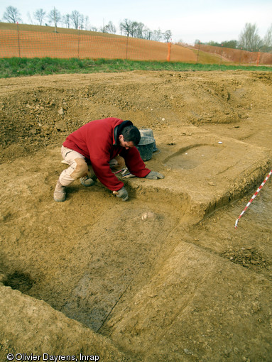 Nettoyage manuelle d'une s&eacute;pulture, cimeti&egrave;re m&eacute;di&eacute;val de Marsan (Gers), 2008.  La diff&eacute;rence de couleur et de texture entre le comblement et le s&eacute;diment encaissant permet de d&eacute;limiter le creusement de la s&eacute;pulture. 