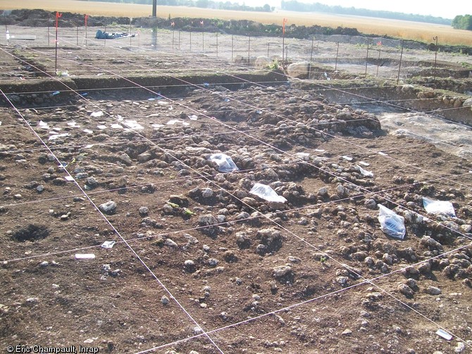 Système de carroyage, Épieds-en-Beauce (Loiret), 2010.  Un carroyage de 1 m de côté  a été mis en place sur la totalité de l'enclos (400 m2) afin de fouiller la couche de rejet de bûcher funéraire. Il permet la localisation des prélèvements, ainsi que de la céramique en vue des remontages. Les collages entre carrés permettant de comprendre le dépôt. 