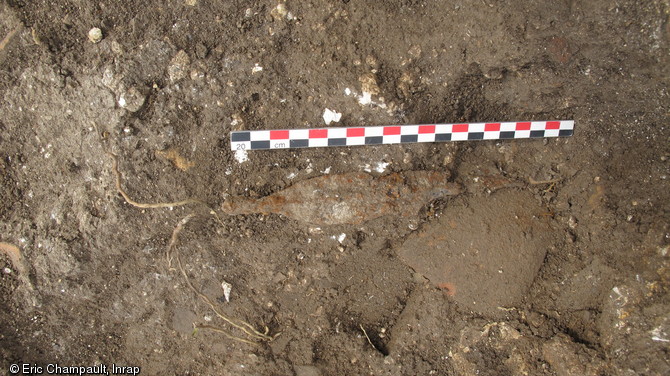 Fer de lance à arête centrale et tesson d'amphore découverts dans l'enclos, première moitié du Ier s. de notre ère, Épieds-en-Beauce (Loiret), 2010.  De nombreuses armes, des éléments de vaisselle ainsi que des ossements humains et animaux attestent de la vocation cultuelle et funéraire de l'espace, associant des pratiques romaines (l'enclos funéraire) et gauloises (bri d'armes). 