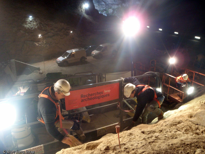 Nettoyage des couches archéologiques supérieures. A l'arrière-plan à droite le relevé de la paroi. Grotte du Mas d'Azil (Ariège), 2012.  Le diagnostic a fait apparaître des couches très riches en vestiges lithiques et osseux, constituées par les activités des occupants du Paléolithique supérieur. 