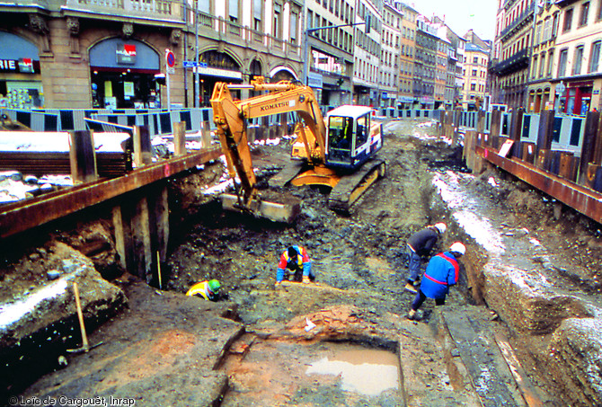 Fouille menée sur le tracé du tramway de Strasbourg (Bas-Rhin) en 1992-1993.  Cette intervention en milieu urbain a permis d'obtenir des données stratigraphiques importantes pour les périodes antique et médiévale.  Photo publiée dans l'ouvrage Archéologie médiévale en France - Le second Moyen Âge, Joëlle Burnouf, coll. Archéologies de la France. 