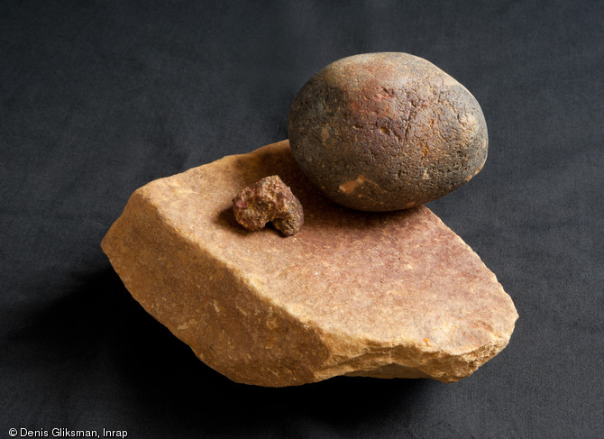 Outils de broyage recouvert de pigment rouge et, au centre, l'un des plus gros fragments d'oxyde de fer d&eacute;couvert sur le site. Pal&eacute;olithique sup&eacute;rieur, Auneau (Eure-et-Loir), 2011.  L'oxyde de fer r&eacute;duit en poudre est utilis&eacute; pour les activit&eacute;s de tannage.